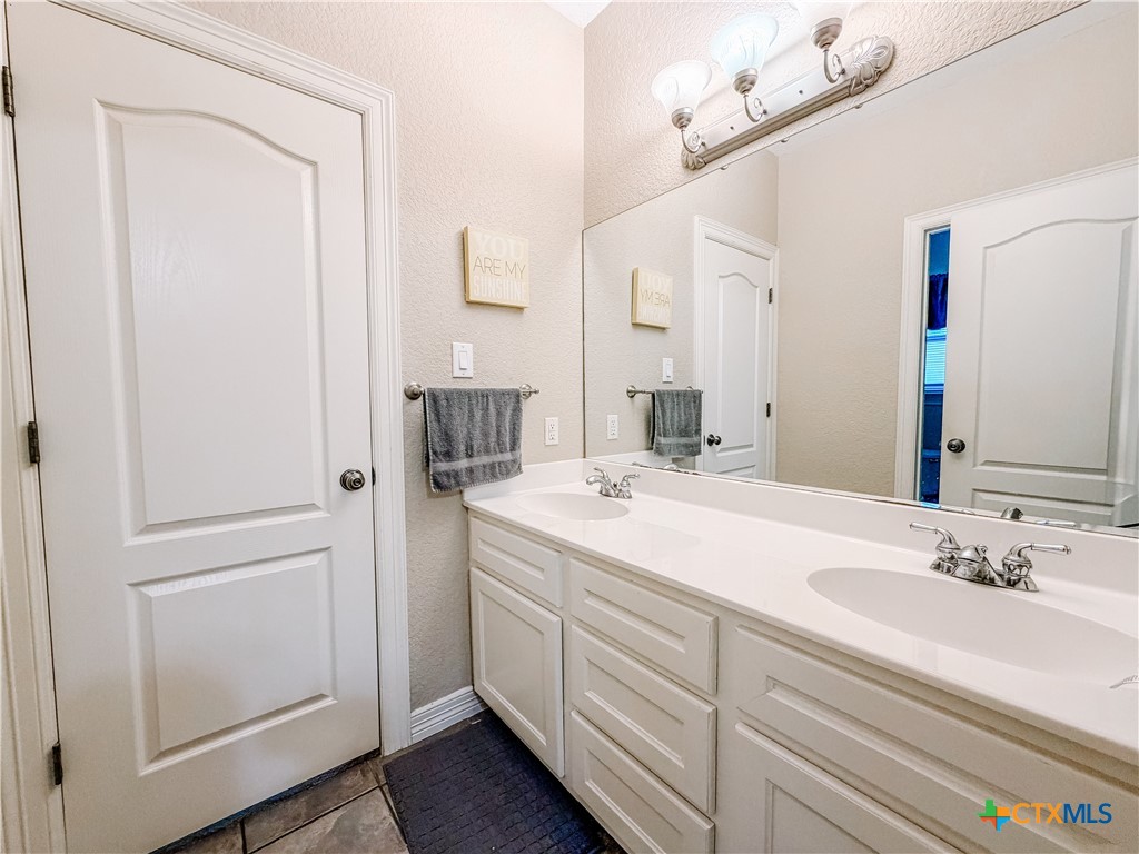 1027 Stagecoach Trail San Marcos, TX 78666 - Photo 17 of 36 a bathroom with a sink and a mirror