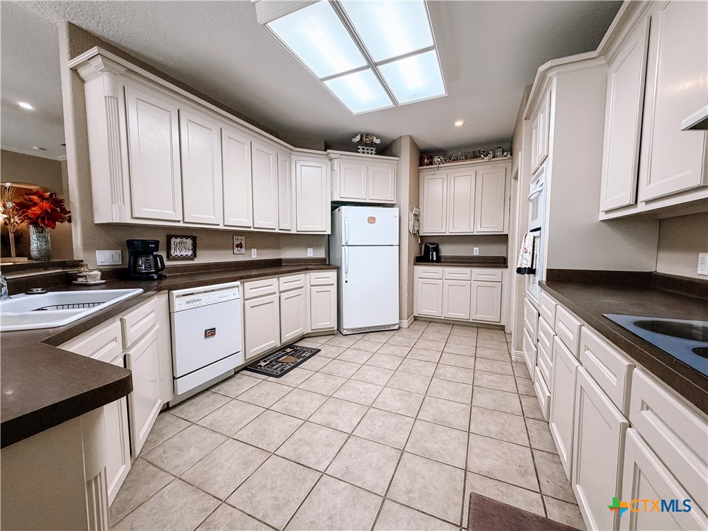 1027 Stagecoach Trail San Marcos, TX 78666 - Photo 9 of 36 a kitchen with a sink a stove and cabinets