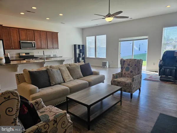 a living room with furniture a ceiling fan and a rug