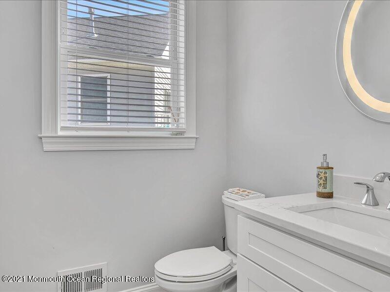 401 8th Avenue Seaside Heights, NJ 08751 - Photo 11 of 45 a bathroom with a toilet a sink a vanity and a window
