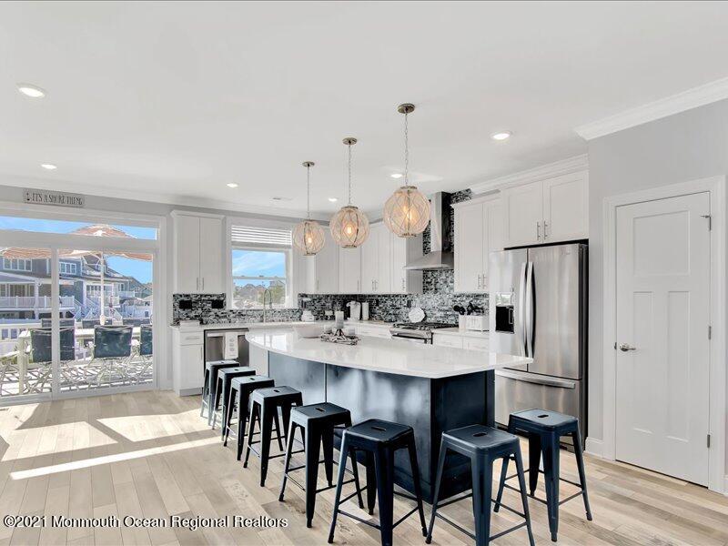 401 8th Avenue Seaside Heights, NJ 08751 - Photo 5 of 45 a kitchen with stainless steel appliances kitchen island granite countertop a table chairs and a refrigerator