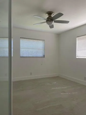 an empty room with a window and a fan