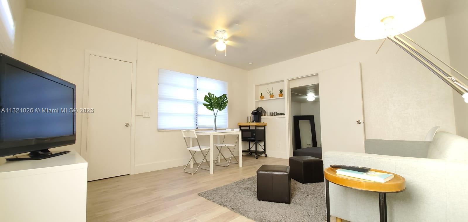a living room with furniture a flat screen tv and a table