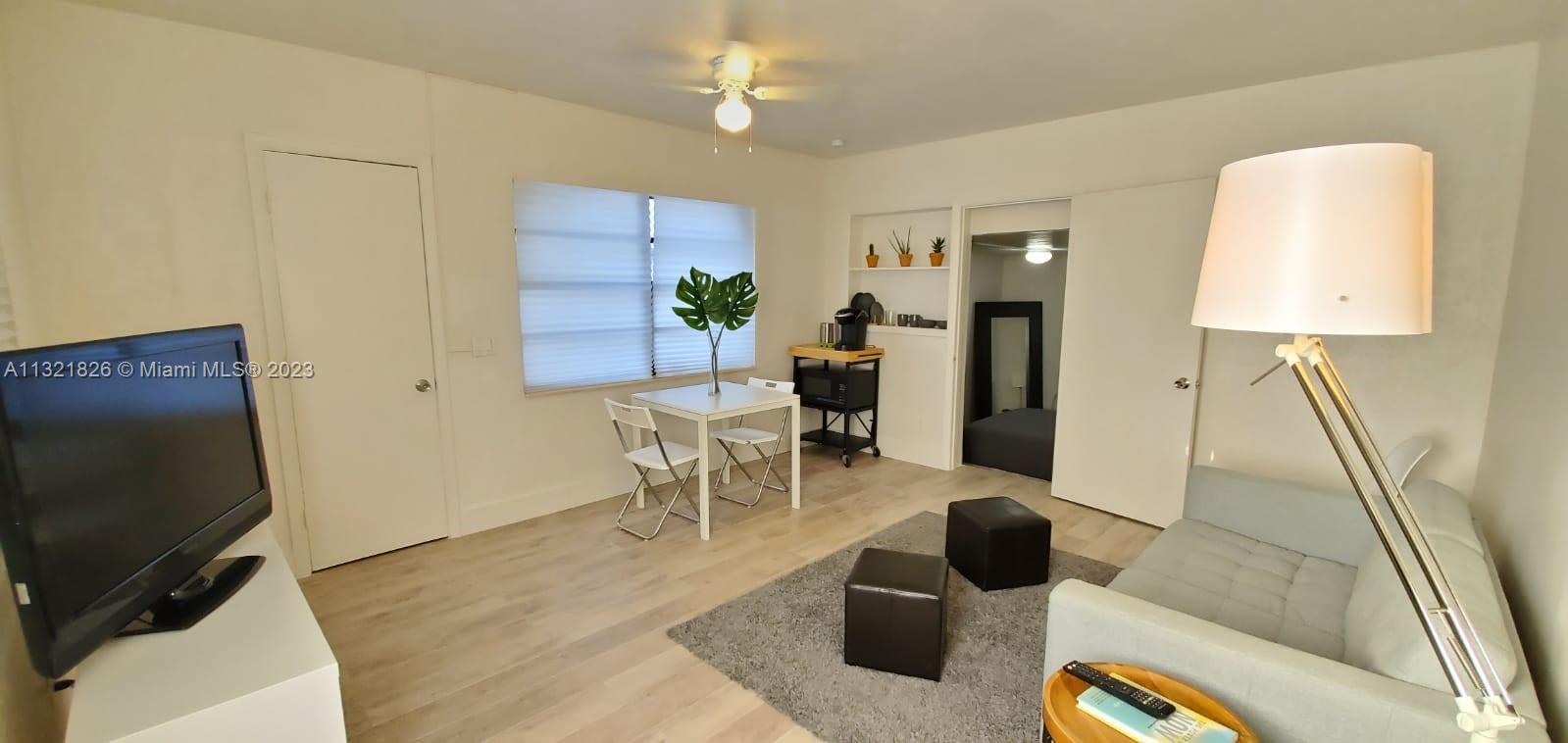 275 Northwest 46th Street, Unit B Miami, FL 33127 - Photo 2 of 9 a living room with furniture and a flat screen tv