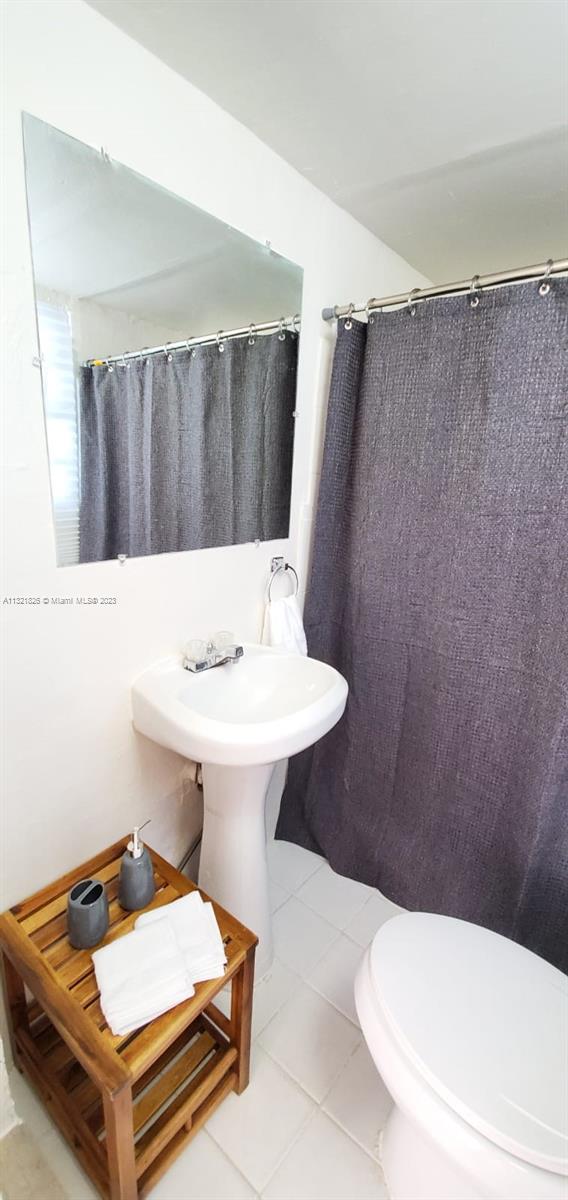 275 Northwest 46th Street, Unit B Miami, FL 33127 - Photo 8 of 9 a bathroom with a sink a toilet and mirror