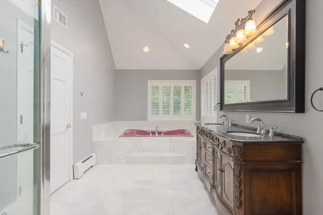 a bathroom with a sink mirror and a bathtub