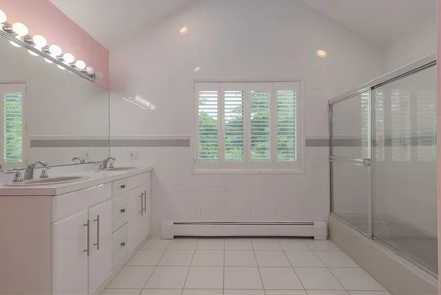 a bathroom with a sink a toilet and large mirror