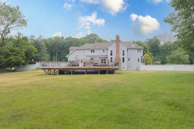 a view of a house with a big yard and large trees