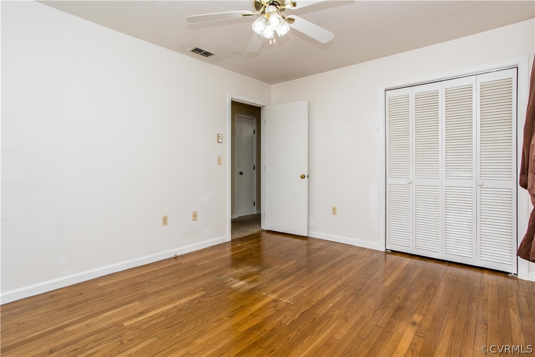 11610 Buckhorn Road Chesterfield, VA 23838 - Photo 16 of 37 an empty room with wooden floor chandelier fan and windows