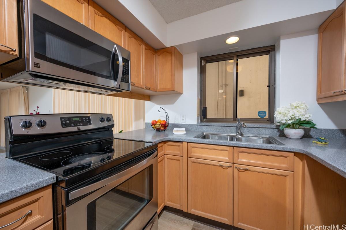 3138 Waialae Avenue, Unit 136 Honolulu, HI 96816 - Photo 4 of 18 a kitchen with stainless steel appliances a sink dishwasher stove microwave and cabinets