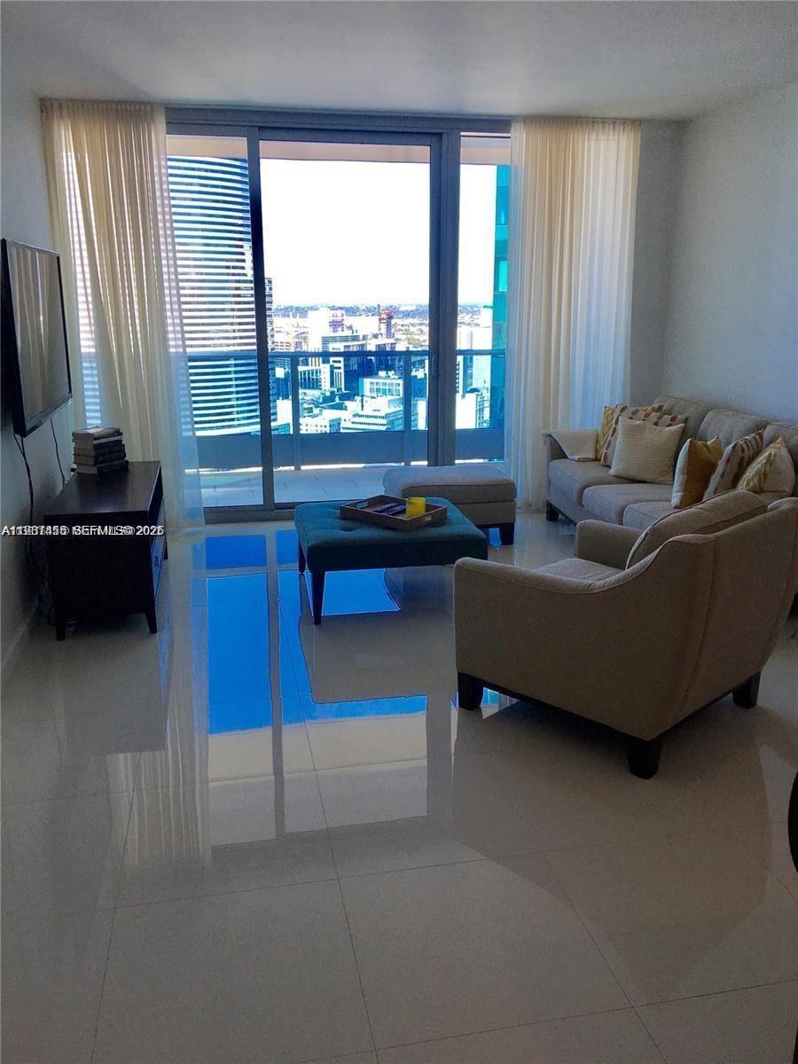 200 Biscayne Blvd Way, Unit 3712 Miami, FL 33131 - Photo 7 of 18 a living room with furniture and a floor to ceiling window