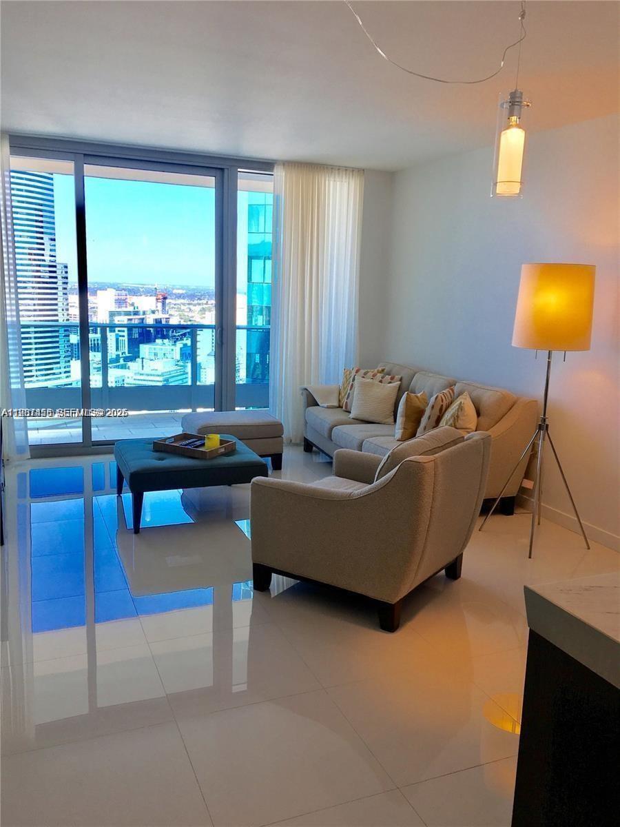 200 Biscayne Blvd Way, Unit 3712 Miami, FL 33131 - Photo 8 of 18 a living room with couch and a floor to ceiling window