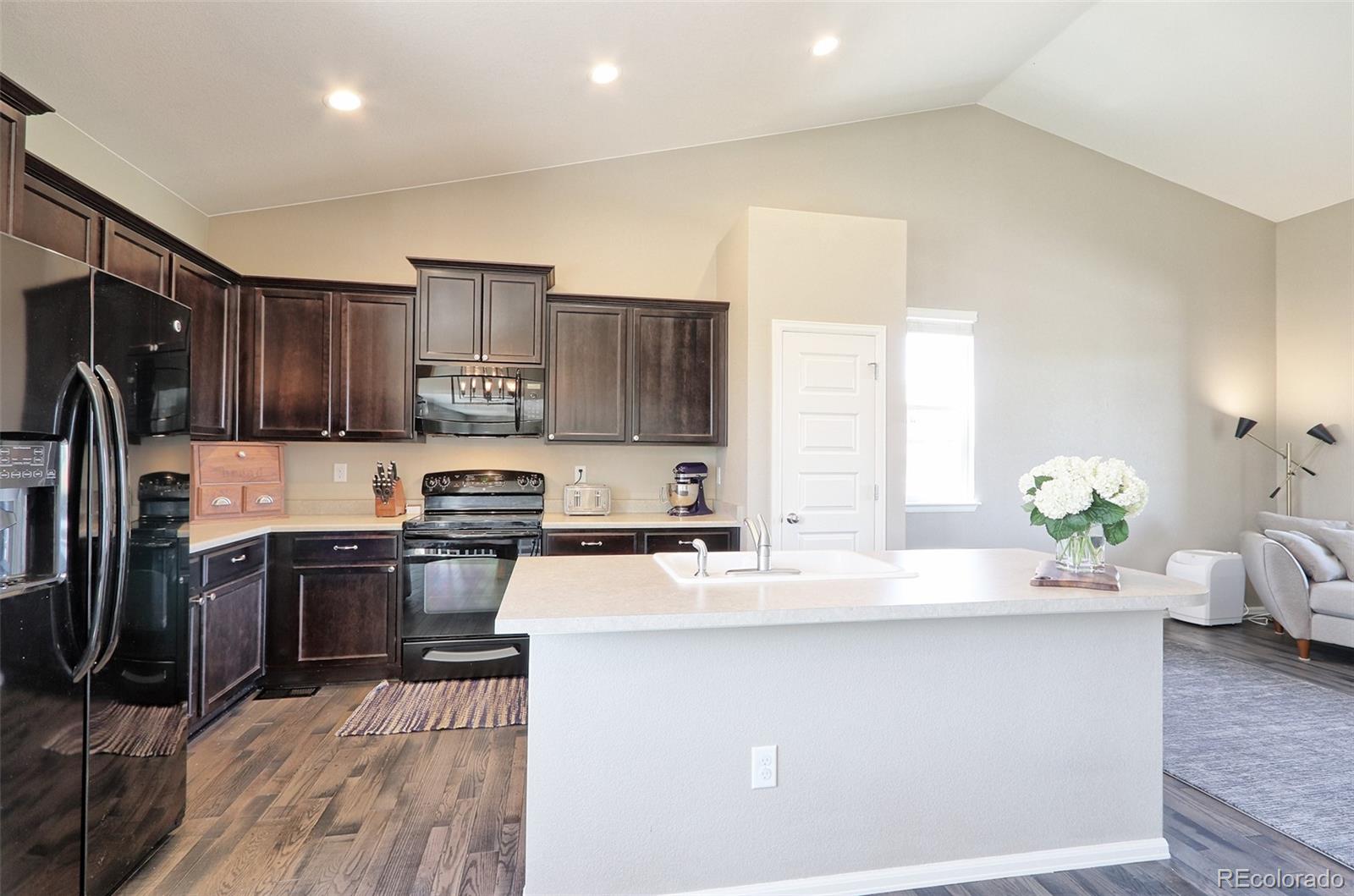 8376 Brandywine Avenue Frederick, CO 80504 - Photo 8 of 31 a kitchen with kitchen island granite countertop a sink stove and refrigerator