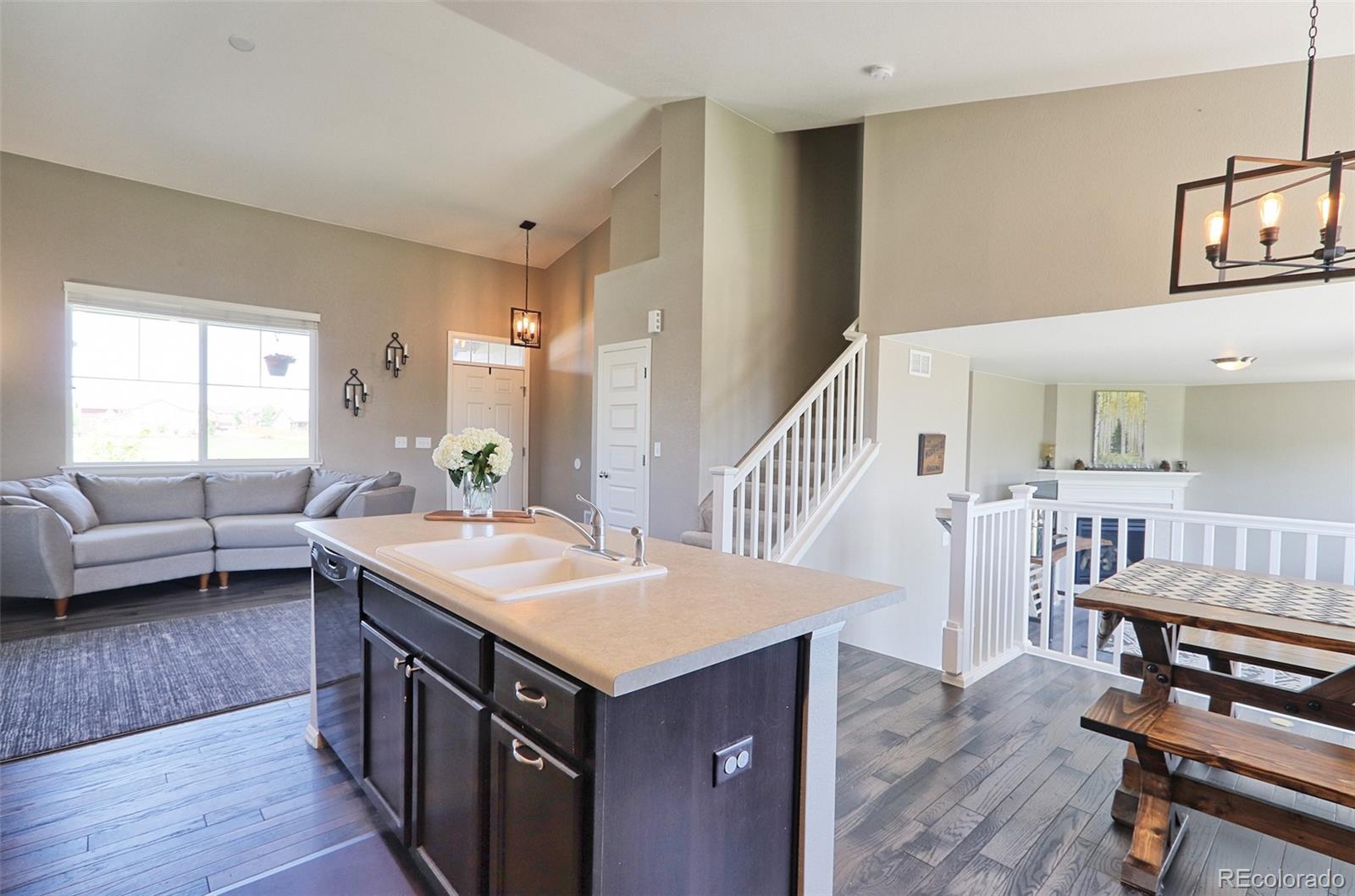 8376 Brandywine Avenue Frederick, CO 80504 - Photo 10 of 31 a view of kitchen island filled with furniture and wooden floor