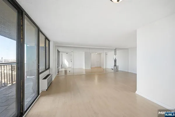 a view of empty room with wooden floor
