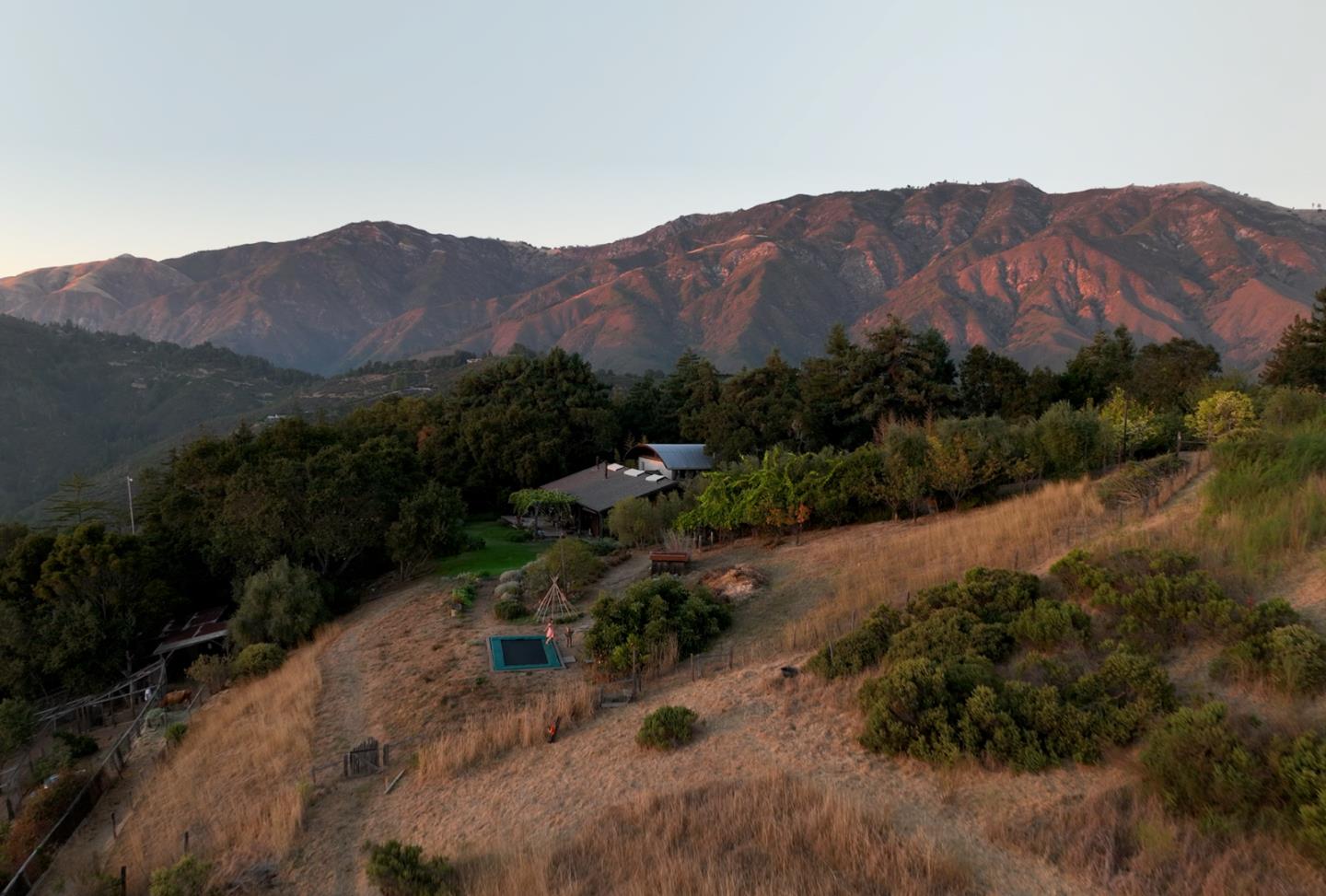 47320 Highway 1 Big Sur, CA 93920 - Photo 27 of 73 a view of a lush green hillside and a houses