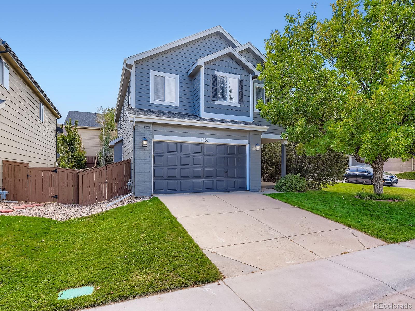 2266 West Ashwood Place Highlands Ranch, CO 80129 - Photo 1 of 48 a front view of a house with a garden and yard