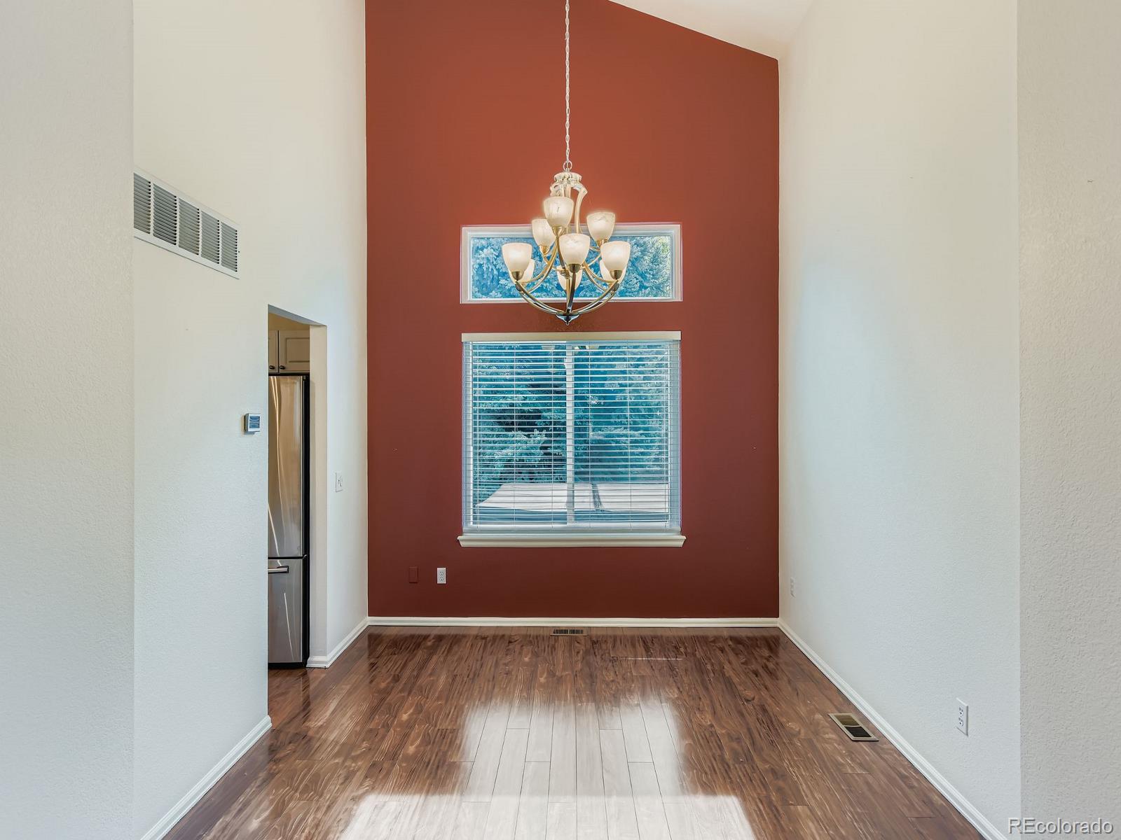 2266 West Ashwood Place Highlands Ranch, CO 80129 - Photo 11 of 48 an empty room with wooden floor and windows