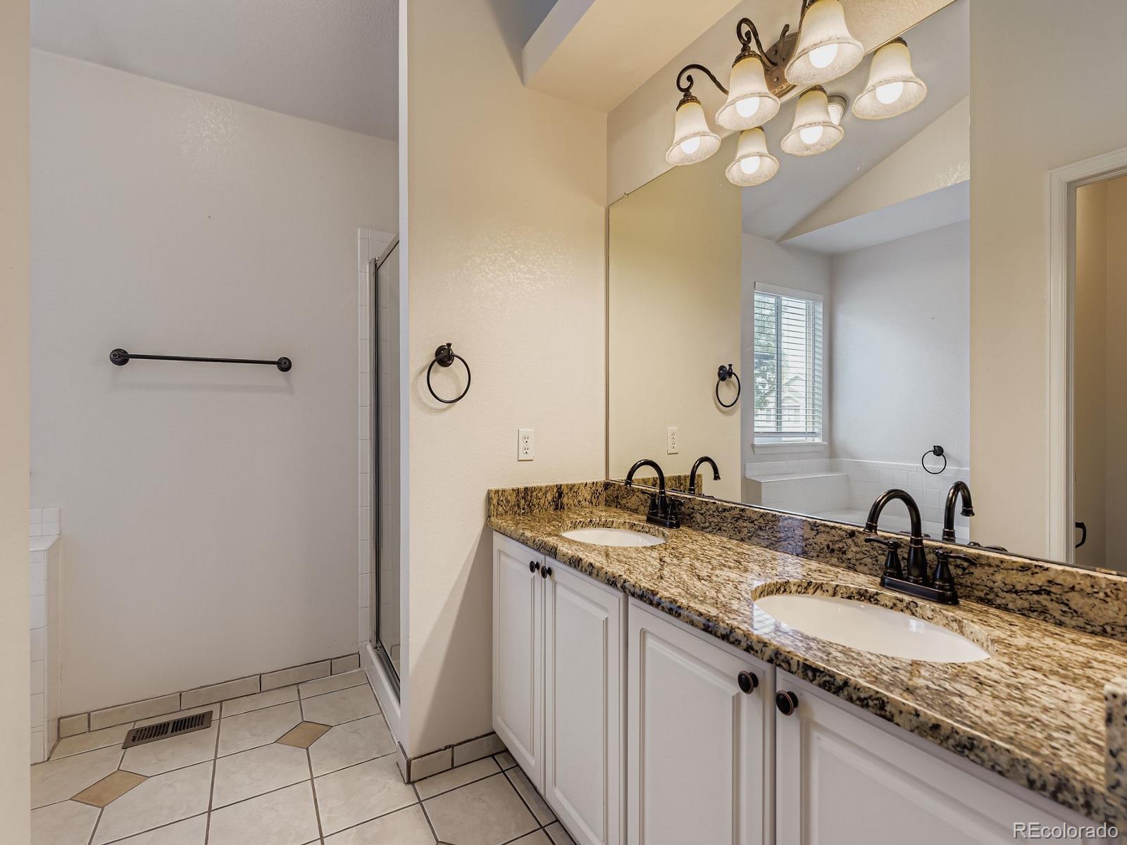 2266 West Ashwood Place Highlands Ranch, CO 80129 - Photo 23 of 48 a bathroom with a granite countertop sink a light fixture and a mirror