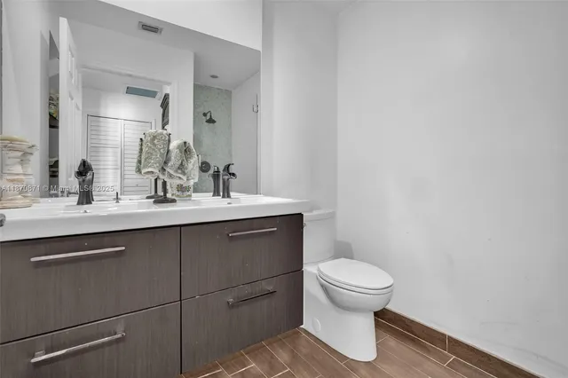 a bathroom with a sink a toilet and mirror