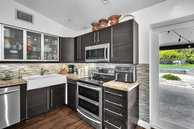 a kitchen with stainless steel appliances a stove sink and microwave