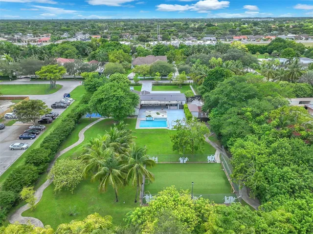 an aerial view of residential houses with outdoor space and trees