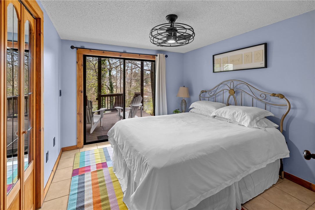 203 Little Lane Seneca, SC 29672 - Photo 29 of 48 This spacious bedroom offers direct access to an inviting outdoor deck, blending comfort with nature.