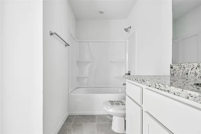 a bathroom with a granite countertop toilet a sink and bathtub