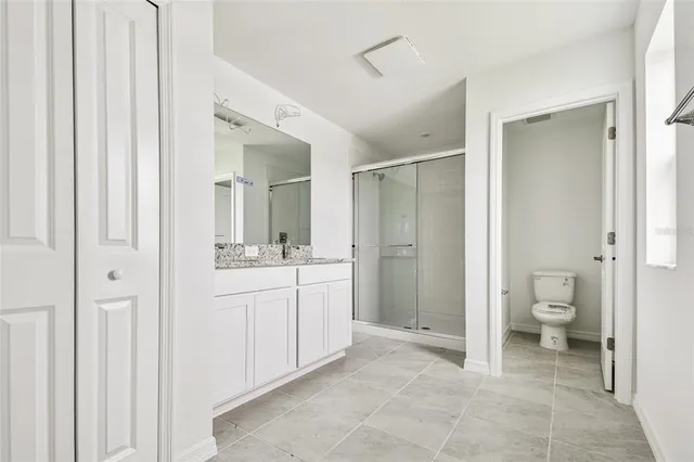a bathroom with a granite countertop sink mirror and toilet