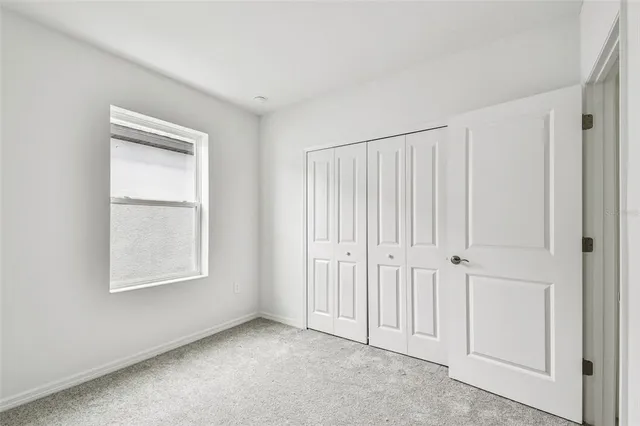 an empty room with windows and closet