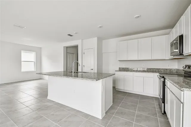 a kitchen with stainless steel appliances granite countertop a sink and cabinets