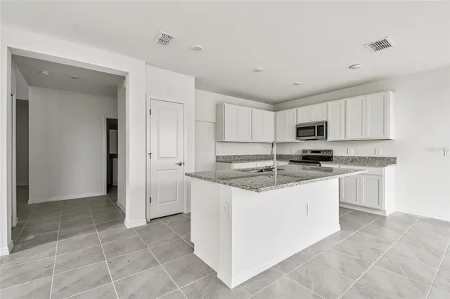 a kitchen with stainless steel appliances granite countertop a sink and cabinets