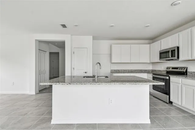 a kitchen with stainless steel appliances granite countertop a sink and a stove