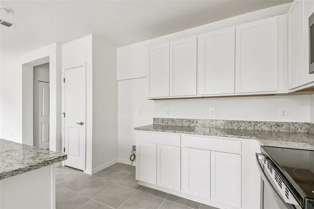 a kitchen with stainless steel appliances granite countertop white cabinets and a granite counter tops