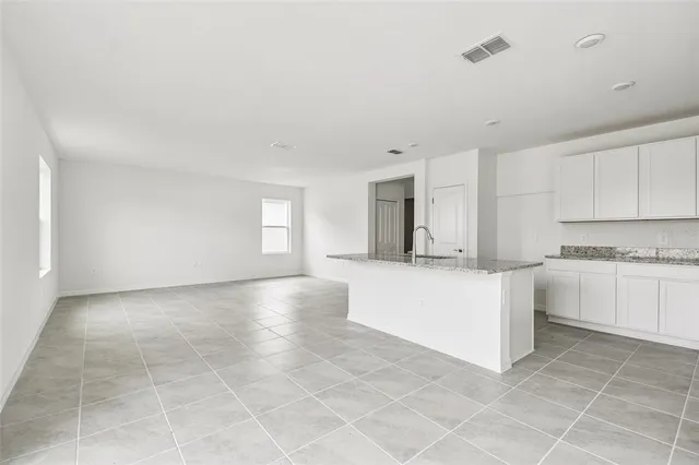 a kitchen with stainless steel appliances granite countertop a stove a sink and white cabinets
