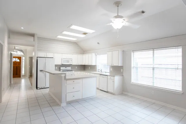 a kitchen with white cabinets and appliances