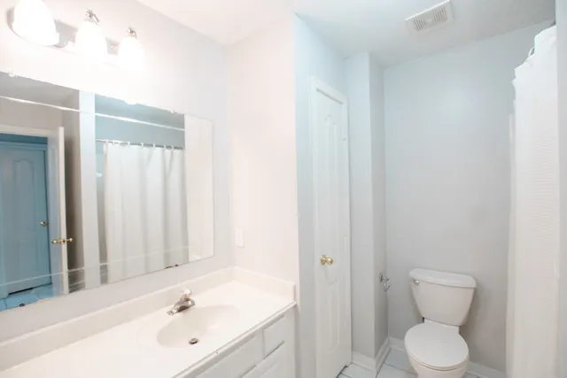 a bathroom with a toilet a sink and mirror