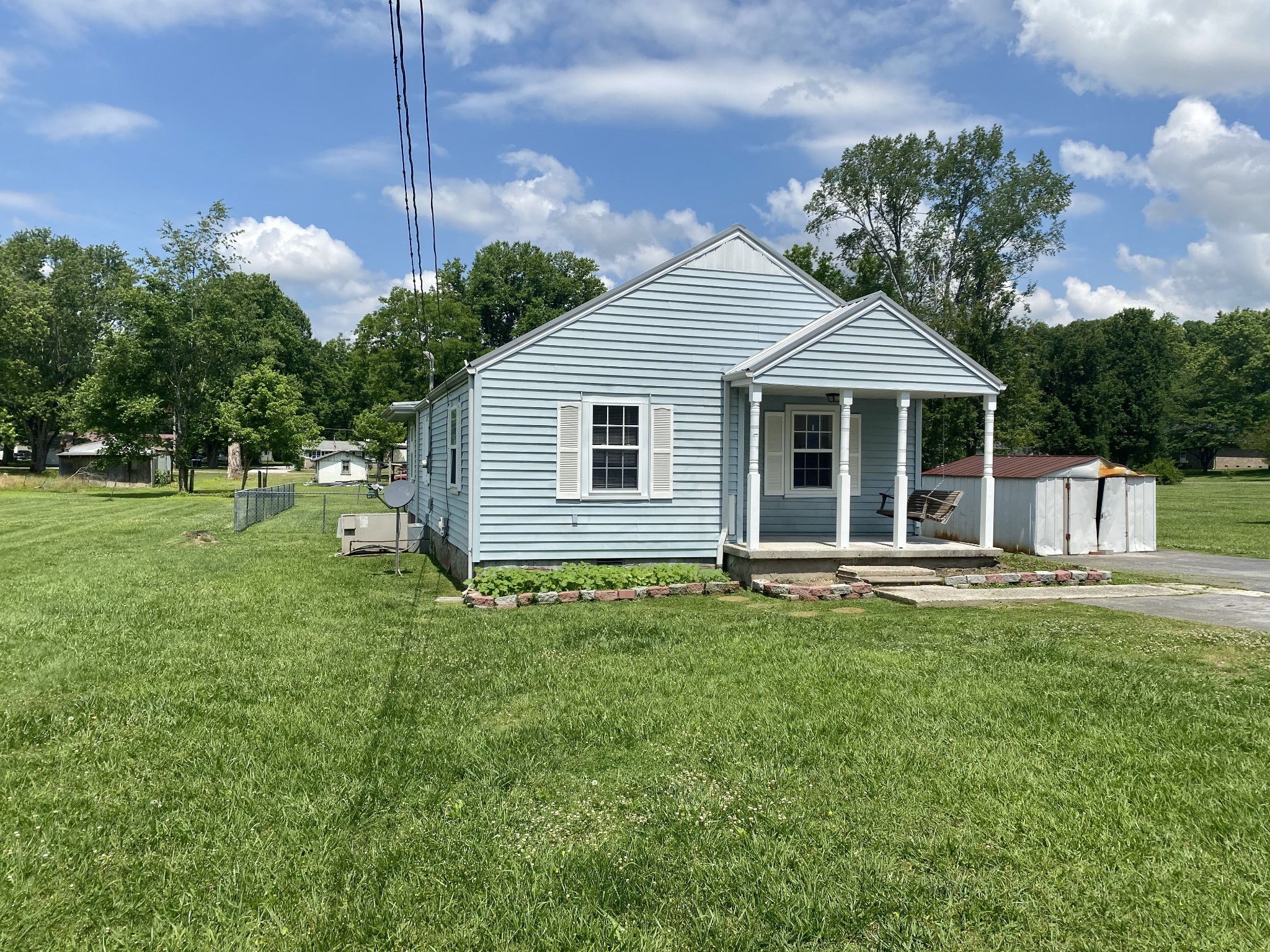 271 Hunt Street Manchester, TN 37355 - Photo 2 of 21 a backyard of a house with table and chairs plants and large tree
