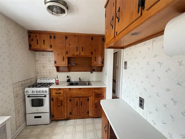 a kitchen with a stove a sink and a refrigerator