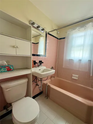 a bathroom with a sink mirror bathtub and toilet