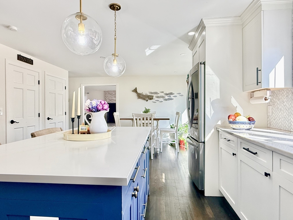 117 A P Newcomb Road Brewster, MA 02631 - Photo 17 of 42 a kitchen with kitchen island a stove a sink and a dining table with wooden floor