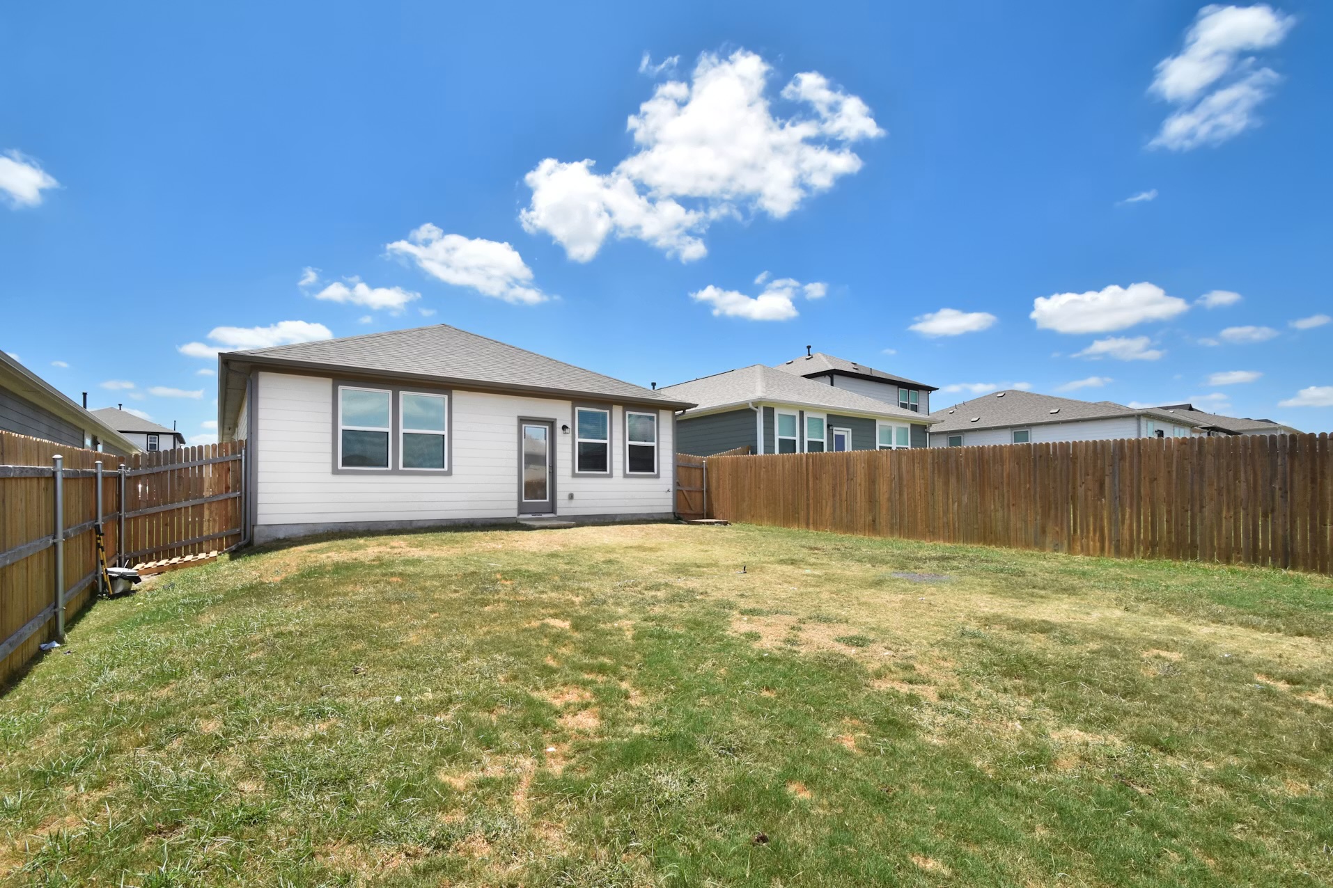 255 Spirit Street Elgin, TX 78621 - Photo 22 of 24 A spacious backyard provides ample green space, enclosed by a privacy fence, perfect for outdoor entertaining