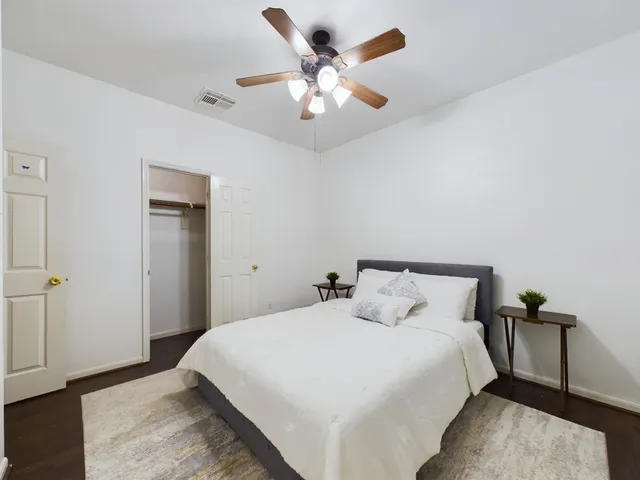 a bedroom with a bed and a ceiling fan
