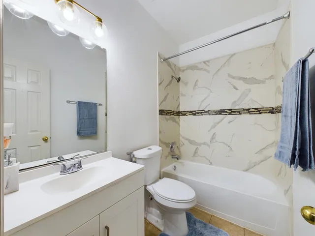 a bathroom with a sink mirror toilet and bathtub
