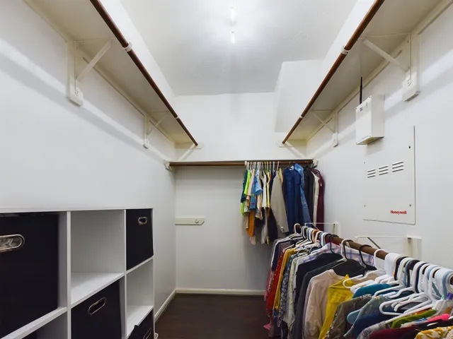 a view of walk in closet with clothes and shoes