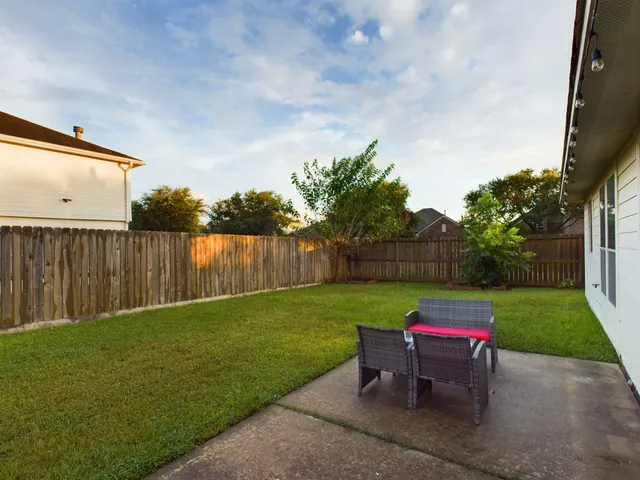 a backyard of a house with table and chairs