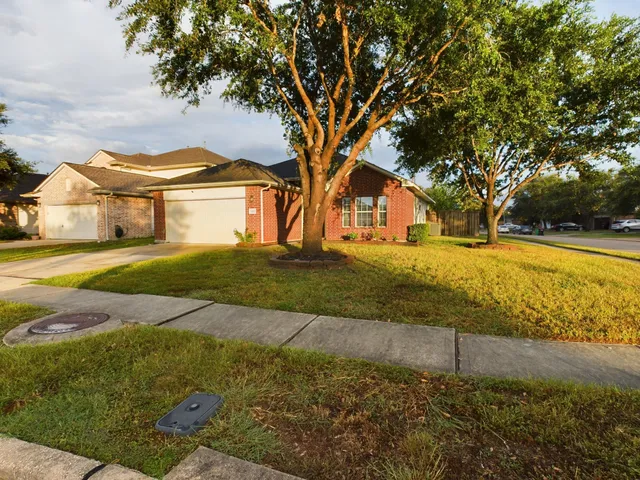 a view of big yard in front of house with trees