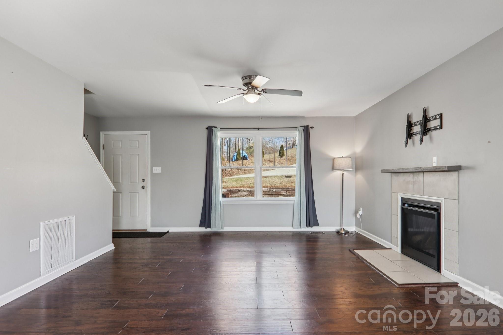 751 Hutch Mountain Road Fletcher, NC 28732 - Photo 8 of 48 a view of an empty room with a fireplace and wooden floor