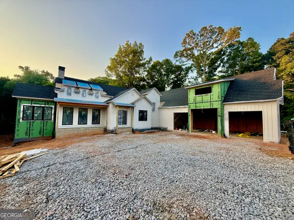 a front view of house with yard and trees in the background
