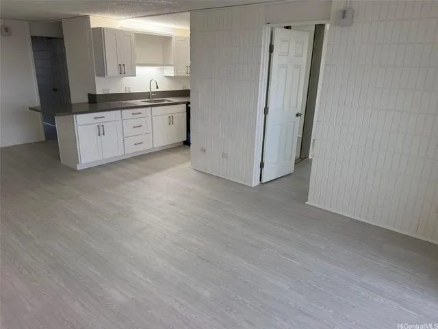 a room with granite countertop a sink and a refrigerator